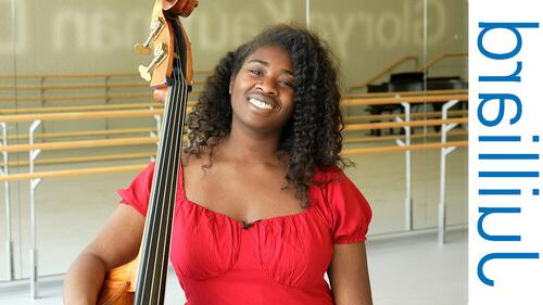 student standing with a stringed instrument